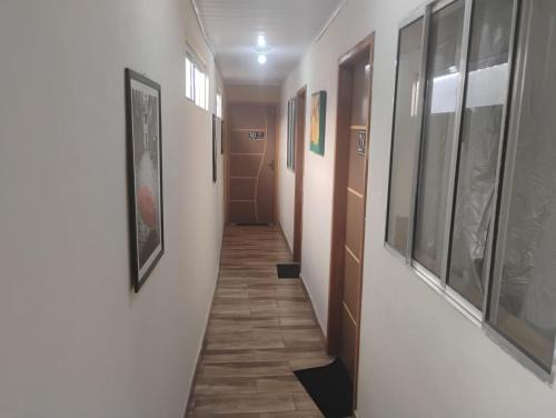 a long hallway with paintings on the walls and a hallwayngthngthngthngthngth at Pousada San Valen in Aparecida