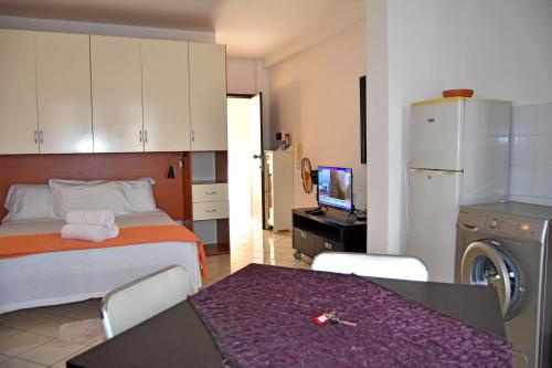 a bedroom with a bed and a table and a kitchen at Central Apartamento Fogo 101 in Santa Maria