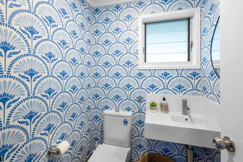 Un baño azul y blanco con inodoro y lavabo. en 7 Egret Street, Peregian Beach - Egrets View, en Peregian Beach