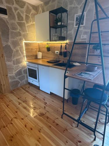 a kitchen with a counter and a table and a ladder at Wooden house Durmitor in Žabljak