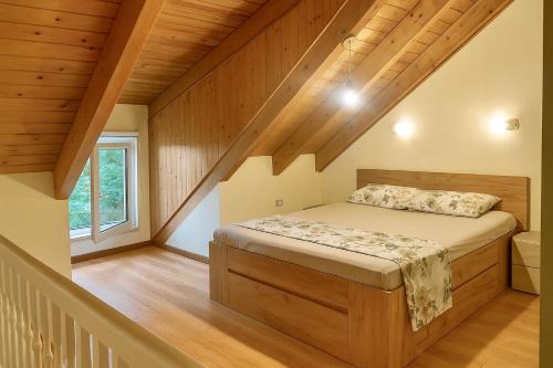 een slaapkamer met een bed in een kamer met houten plafonds bij Beach Villa in Golem in Golem