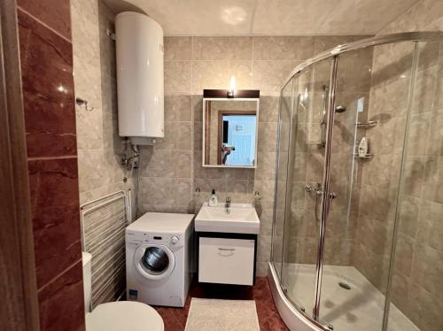 ein Badezimmer mit einem Waschbecken und einer Waschmaschine in der Unterkunft Luxury Coastal Dreams Apartment in Sweti Wlas