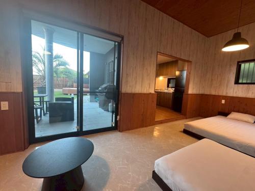 a bedroom with a bed and a table and a window at 館山貸別荘 Arks Del Mare in Funakata