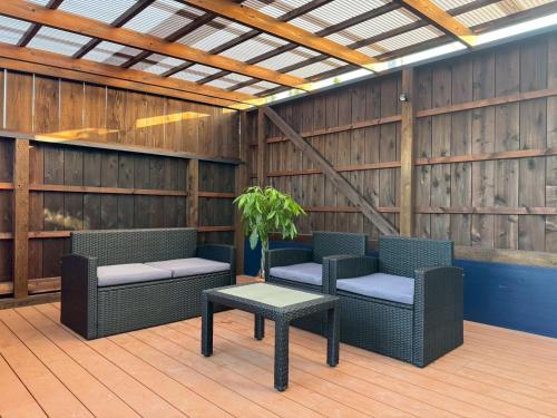 a patio with two wicker chairs and a table at 館山貸別荘 Arks Del Mare in Funakata