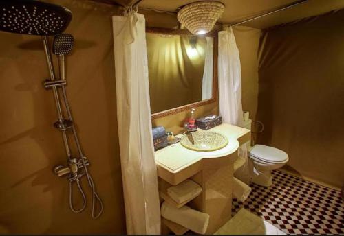 a bathroom with a sink and a toilet and a shower at Desert luxury tents in Merzouga