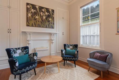 a living room with two chairs and a table at Villa Cambria in Nelson