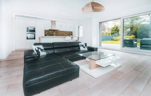 a living room with a black leather couch and a table at Modern 2 Bed with Garden - Bridel in Bridel