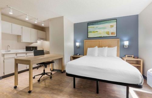 a bedroom with a bed and a desk and a kitchen at Extended Stay America Suites - Arlington - Six Flags in Arlington