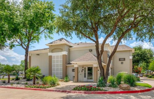 a house with a tree in front of it at Extended Stay America Suites - Arlington in Arlington