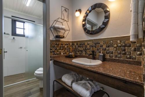 a bathroom with a sink and a toilet at Pousada Vila 505 in Canela