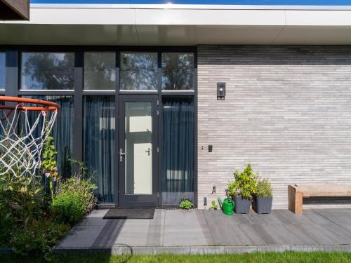 a building with glass doors and a basketball hoop at Holiday Home near Kaag Lakes in Oud-Ade