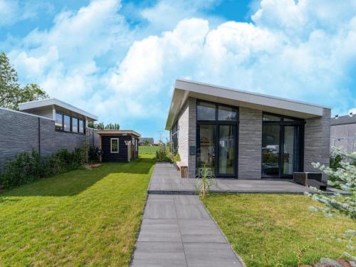 a house with glass doors and a grass yard at Holiday Home near Kaag Lakes in Oud-Ade