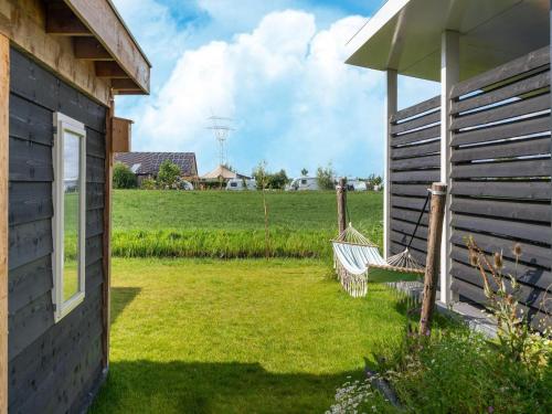 a house with a yard with two chairs and an umbrella at Holiday Home near Kaag Lakes in Oud-Ade