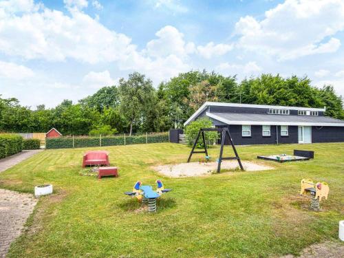 a yard with a playground with a swing at 4 person holiday home in Hampen in Hampen