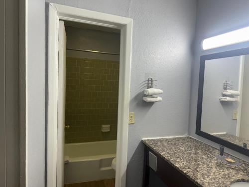Un baño con lavabo, espejo y bañera. en Lake Marion Inn, en Santee