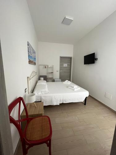 a bedroom with a bed and a chair and a tv at GioLì in Matino