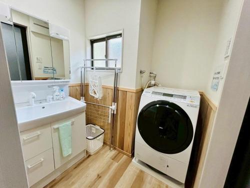 a bathroom with a washing machine and a sink at 時間を忘れる貸別荘オールブルーセカンド in Hatsukaichi
