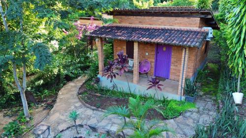 a small house with a purple door in a garden at Pousada Luar do Sertão in Lençóis