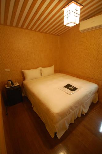 a bedroom with a bed with a book on it at Hananoi Bed and Breakfast in Hengchun