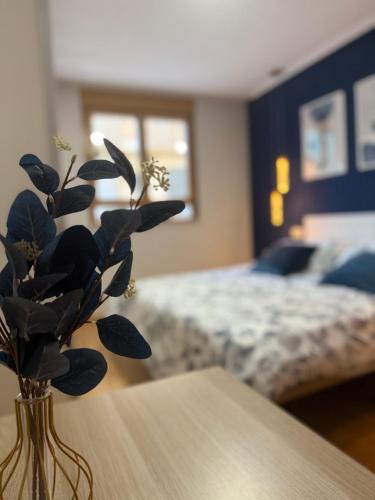 a vase on a table in a bedroom with a bed at Cómodo apartamento a un paso del centro de Salamanca La Posada Charra 6 APART-37-278 in Salamanca