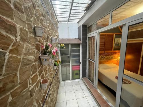 a room with a bed and a stone wall at Family Vacation Beach House - Aouchtam in Aouchtame