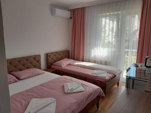 deux lits jumeaux dans une chambre avec fenêtre dans l'établissement Second Sweet Home, à Pristina
