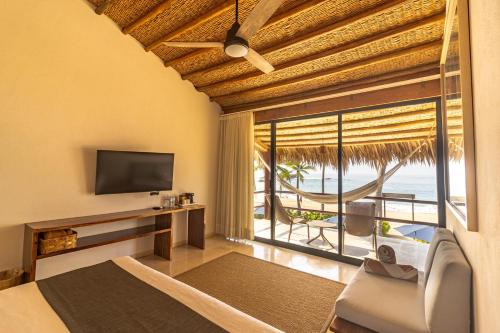 a bedroom with a view of the ocean at Casa Lu Hotel Boutique in Mazunte