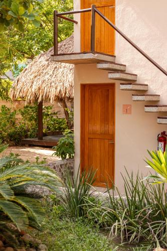 a small house with a wooden door and stairs at Casa Lu Hotel Boutique in Mazunte