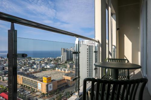 a balcony with a table and a view of a city at Hotelaround Sokcho in Sokcho