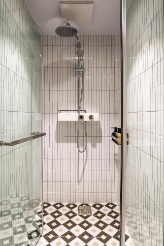 a shower in a bathroom with a black and white floor at Hotelaround Sokcho in Sokcho