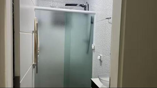 a bathroom with a glass shower with a toilet at Casa Aconchegante de Praia in Caraguatatuba