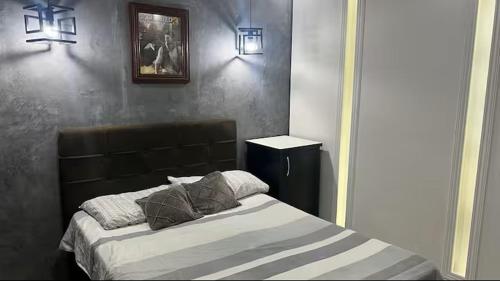 a bedroom with a bed and a picture on the wall at Casa Aconchegante de Praia in Caraguatatuba