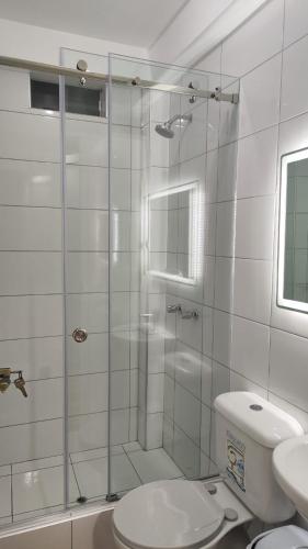 a bathroom with a shower with a toilet and a sink at Mamre Guest House Tacna - Hospedaje in Tacna
