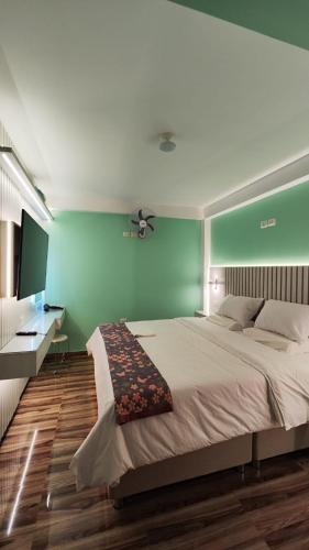 a bedroom with a large bed with a green wall at Mamre Guest House Tacna - Hospedaje in Tacna
