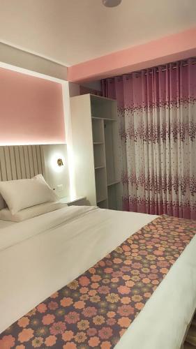 a bedroom with a white bed with a rug on it at Mamre Guest House Tacna - Hospedaje in Tacna
