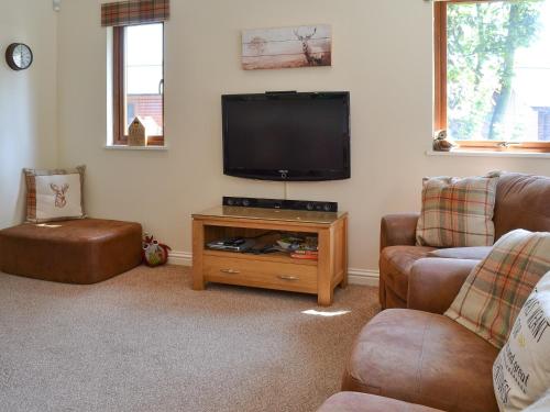 a living room with two couches and a flat screen tv at Pine Lodge in Sewerby