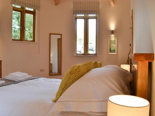 a bedroom with a white bed with two windows at The Horse Gin - Uk11024 in East Worlington