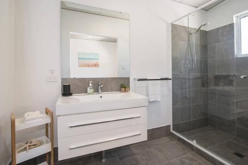 a bathroom with a white sink and a shower at Beach Bum Bungalow 1- WIFI, Short walk to the beach in Busselton
