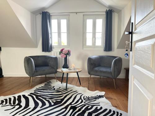 a living room with two chairs and a zebra rug at Villa La Renaissance - Etretat in Étretat