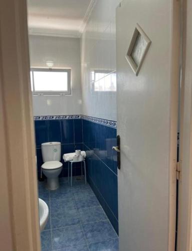 a blue and white bathroom with a toilet and a sink at Villa Diki beach in Ksar es Sghir