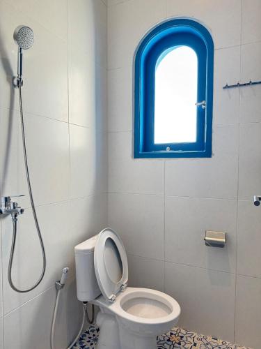 a bathroom with a toilet and a window at Calosa Villa in Batu