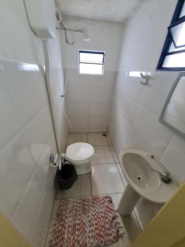 a small bathroom with a toilet and a sink at Kitnet Encanto Astral in São Thomé das Letras
