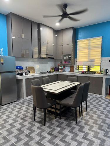 a kitchen with a table and chairs and a refrigerator at Homestay Kamilia in Bachok