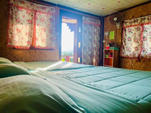 a large bed in a room with a window at รักเขาอินทนนท์โฮมสเตย์ Doi inthanon Homestay in Ban Yang Di Pha Mop
