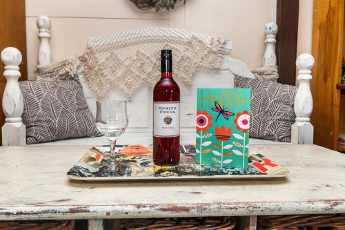 a bottle of wine and a glass on a table at Cabin close to FL Caverns! Pool, WI-FI, & Firepit in Marianna