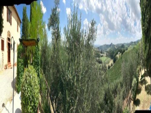 a view of a valley with trees and a house at Montana Escape, Tuscan Stay in Chiusdino