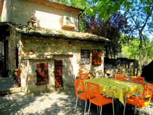 a table and chairs in front of a stone house at Montana Escape, Tuscan Stay in Chiusdino