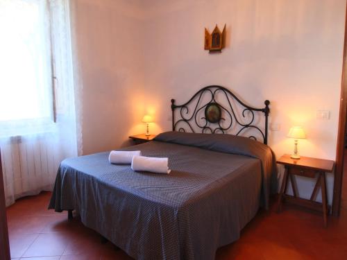 a bedroom with a bed with a blue blanket and two lamps at Farmhouse with Pool – Pets Welcome! in Gualdo Cattaneo