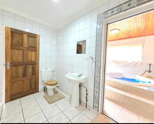 a bathroom with a toilet and a sink and a tub at Dream vacation home in Vanderbijlpark