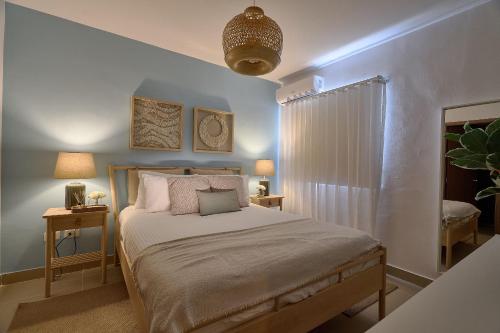 a bedroom with a bed and two tables with lamps at Charming 1Bdrm Apt. 10mins from Punta Cana Beaches in Punta Cana